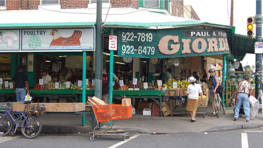 a group of people walking down a street in front of a store