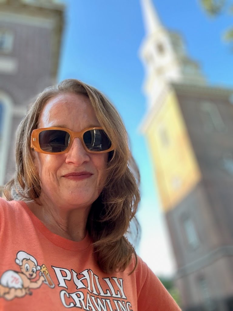 JPEG image-4D49-8735-DA-0 a woman wearing glasses and smiling at the camera
